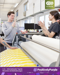 Werkstatt, zwei Personen an einer großen Maschine, eine Person gebärdet. Logo „gw ST. PÖLTEN“. Text: „3.12. - Internationaler Tag der Menschen mit Behinderungen“, „#PositivelyPurple“, „powered by PurpleSpace“, „supported by myAbility“.