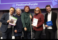 Fünf Personen vor Leinwand mit Text „#PositivelyPurple“. Dokumente: „Beschäftigung“, „Zero Project Report 2025“, „Employment and ICT“, Karte „ÖNB“.