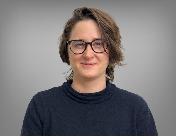 Portrait von Sophia Neuwirth. Sie hat kurze braune Haare und eine Brille. Sie trägt einen schwarzen Pullover.