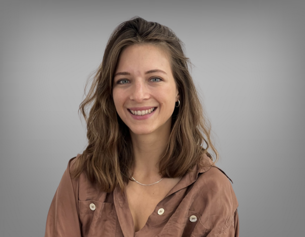 Portrait von Ines Vollnhofer, sie hat schulterlanges braunes Haar mit einem braunen Hemd.