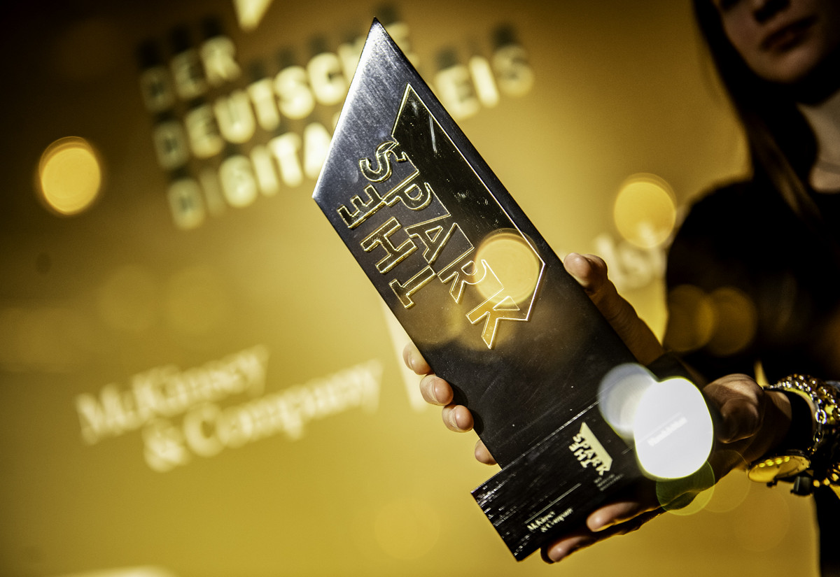 Eine goldene Trophäe mit der Aufschrift „The Spark“ wird feierlich präsentiert.