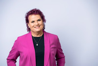 Lena Öllinger mit violetten Haaren und pinkem Blazer