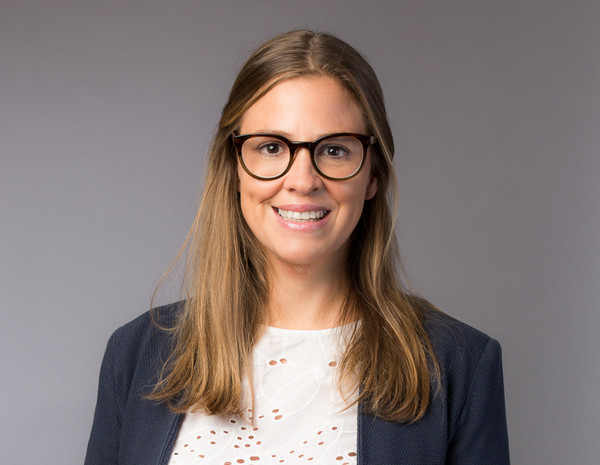 Portrait von Pia Leichtfried, weiblich gelesene Person mit schulterlangem blondem Haar und blauem Blazer