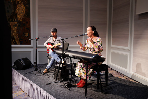 Das musikalische Duo "Satuo" bei ihrem Auftritt beim Abendevent. Die Sängerin singt voller Emotionen und hebt dabei ihre Hände in die Luft.