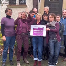 Screenshot eines Videos auf dem ein Team in lila Kleidung ein lila Blatt zu PurpleLightUp hochhält.
