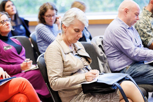 Workshop-Teilnehmende am DCD. Frau schreibt auf einem Block mit.