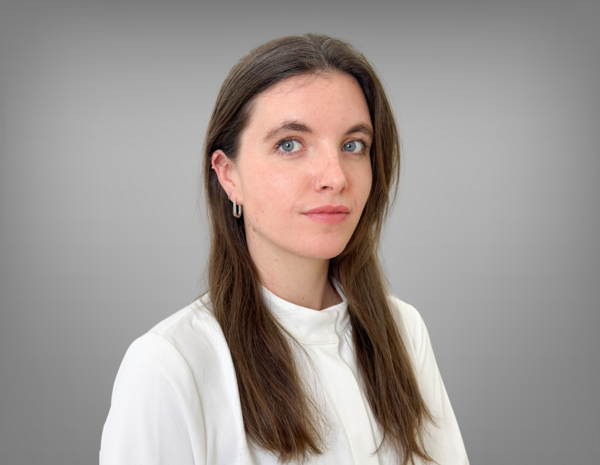 Portrait von Zoe Seitz. Sie hat langes braunes Haar und trägt ein weißes T-Shirt. 