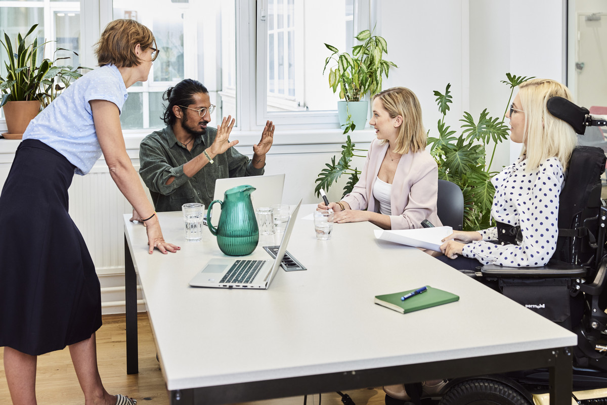 Meetingssituation mit drei weiblich und einer männlich gelesenen Person