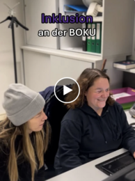 Inklusion an der BOKu. Zwei Personen sitzen an einem Schreibtisch. Playbutton in der Mitte des Bildes.