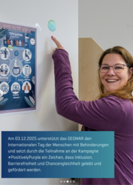 Person mit langen Haaren und lila Oberteil zeigt auf ein Plakat zum Thema Behinderungen