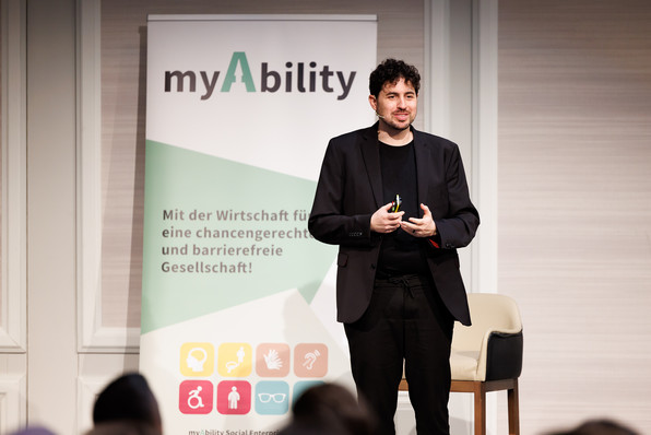 Roi Shternin lächelt bei seiner Keynote ins Publikum.