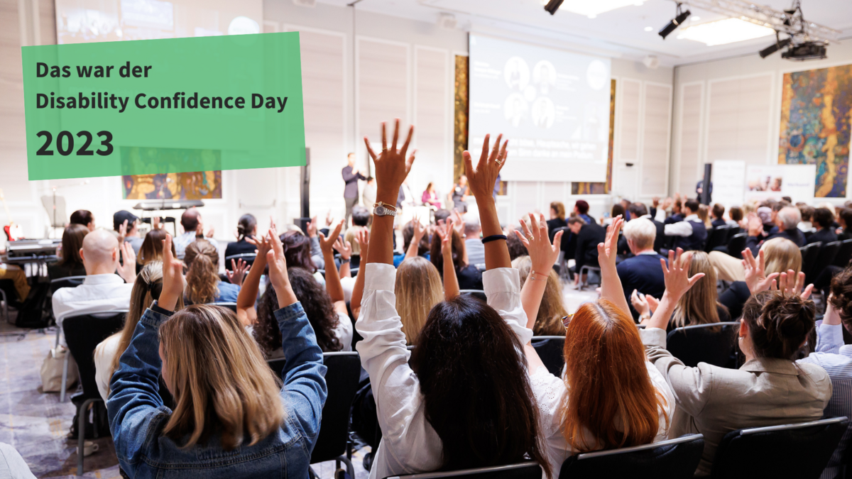 Das Publikum des Abendevents des DCD applaudiert in Österreichischer Gebärdensprache. Darüber steht: "Das war der Disability Confidence Day 2023".