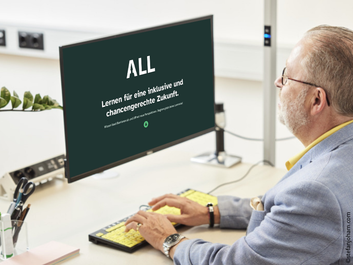 Männlich gelesene Person sitzt vor einem Computerbildschirm. Geöffnet ist das Dashboard von der myAbility digitalen Lernplattform: ALL mit dem Slogan: "Lernen für eine inklusive und chancengerechte Zukunft"