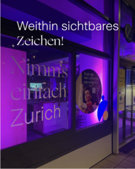 Schaufenster einer Zürich-Filiale erleuchtet mit violettem Licht. Text: Weithin sichtbares Zeichen!