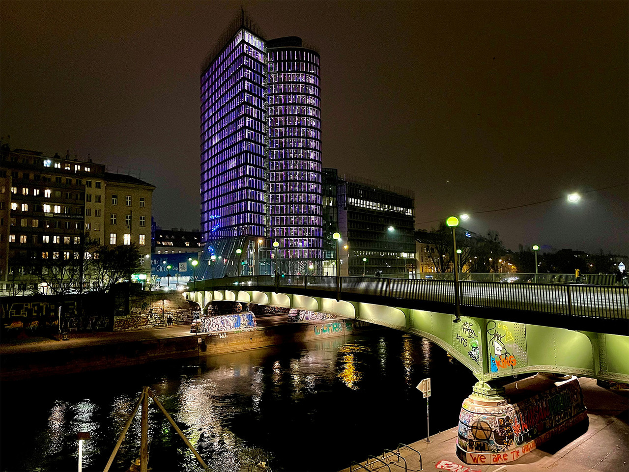 Lila beleuchteter UNIQA Tower am Donaukanal in Wien